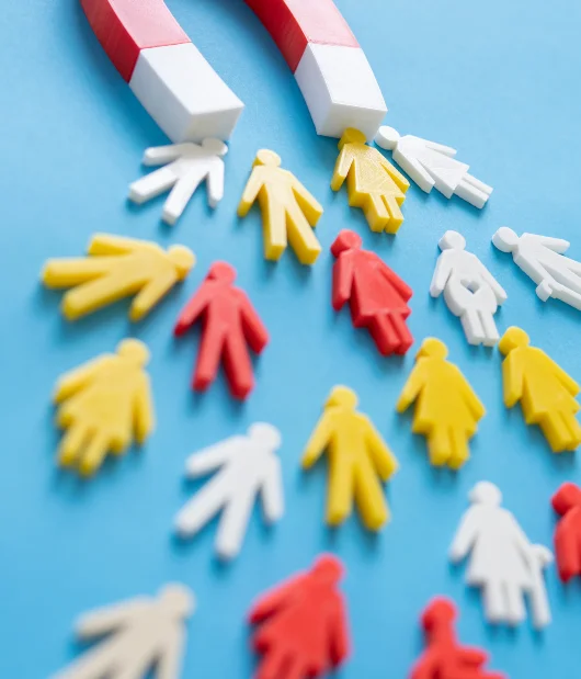 A red and white magnet attracting colorful human-shaped figures, symbolizing lead generation and customer attraction.